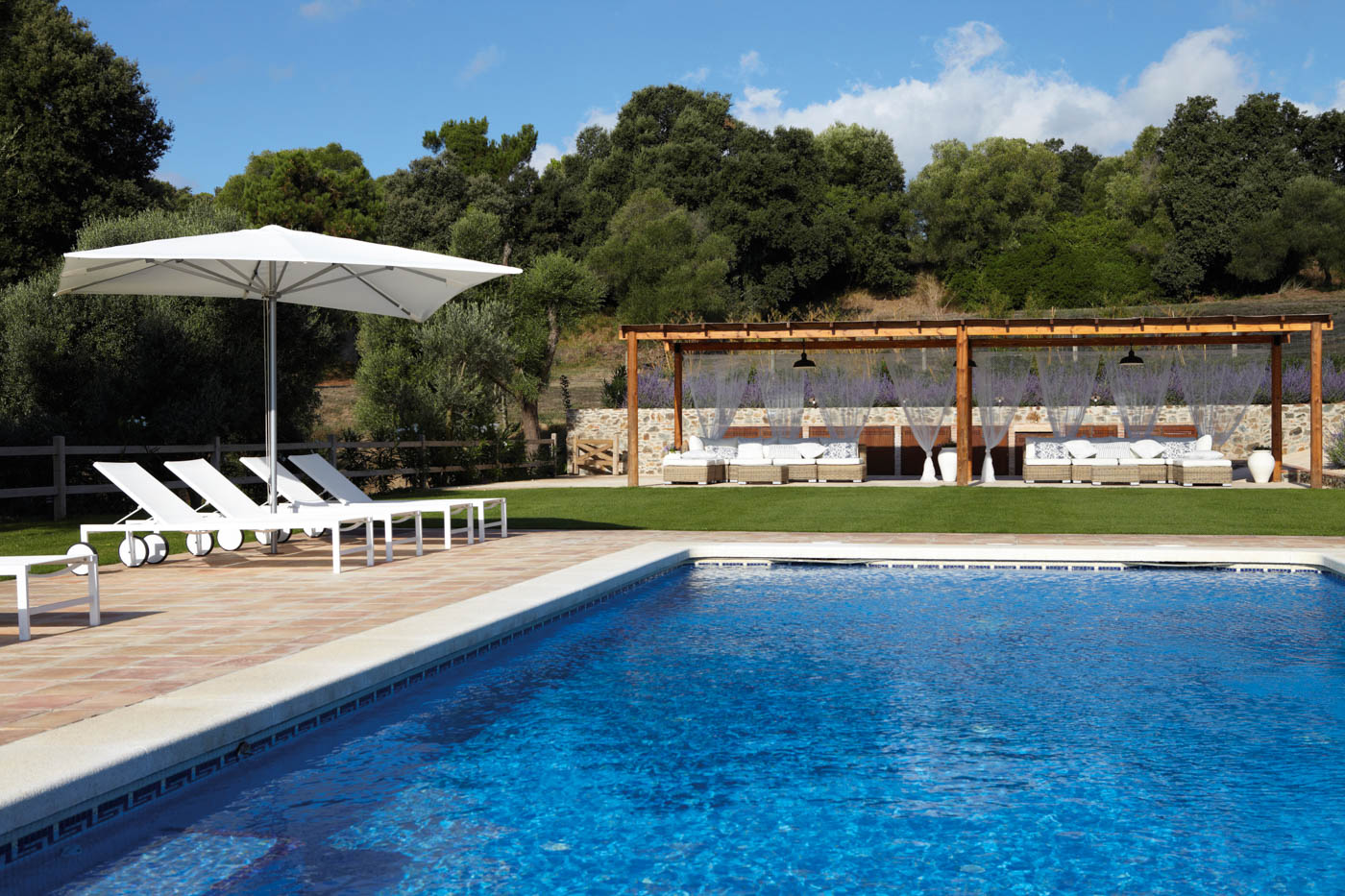 Sunloungers, manicured lawn and pergolas